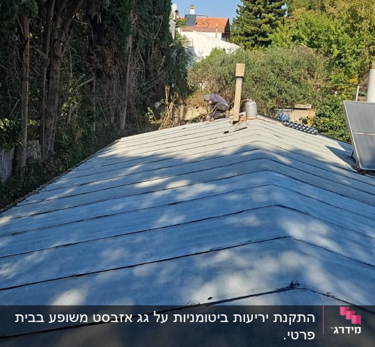 גג עם יריעות איטום ואדם עובד על התיקון